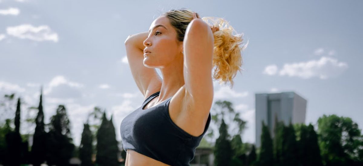 Fit woman in a black tank top enjoys a sunny workout outdoors in Ciudad de México, embracing wellness and healthy living.