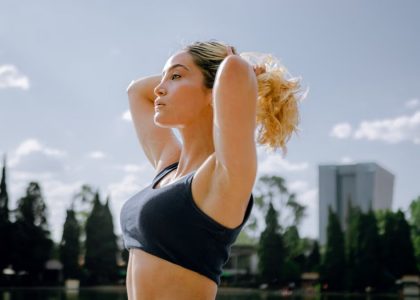 Fit woman in a black tank top enjoys a sunny workout outdoors in Ciudad de México, embracing wellness and healthy living.
